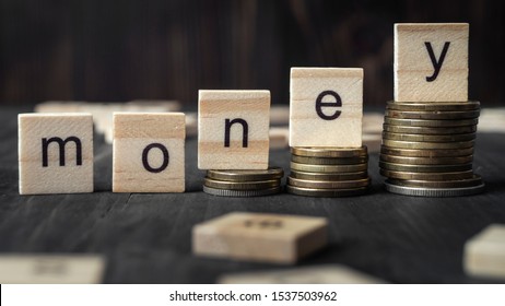Coins on stack stair as step growing growth and wooden cube block with word money, close up