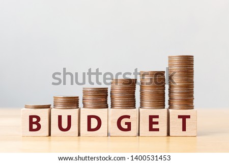 Coins on stack stair as step growing growth and wooden cube block with word BUDGET. Money annual budget concept