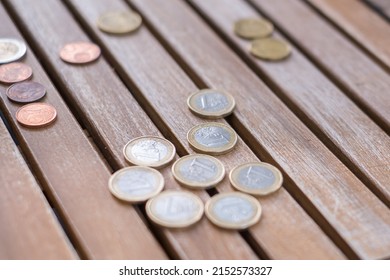coins of one euro, fifty cents, twenty cents, two euros and two euro cents, grouped according to their value, on a wooden slatted table. Tenerife, Canary Islands, Spain