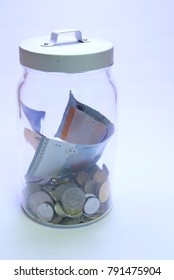 Coins And Paper Money In A Cookie Jar