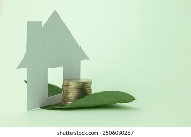 Coins placed on leaves and a house silhouette represent an eco-friendly investment and savings concept. This visual symbolizes green investments and sustainable homeownership. - Powered by Shutterstock