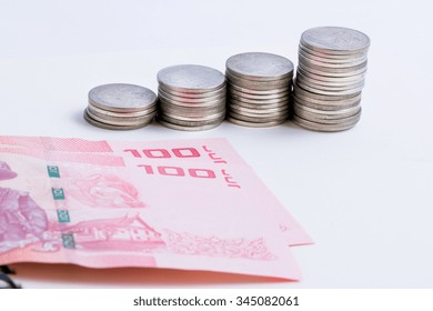 Coins setup in line graph put beside banknote. Financial accounting concept.