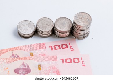 Coins setup in line graph put beside banknote. Financial accounting concept.