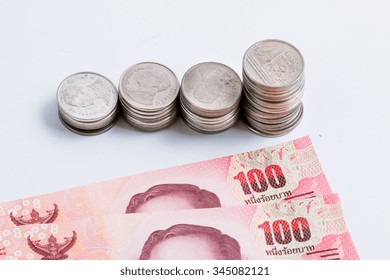 Coins setup in line graph put beside banknote. Financial accounting concept.