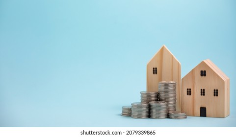 Coins stack in front of wooden home on wooden table, Save money concept, Property investment, house loan, reverse mortgage, gold coins money stack growth, saving money coins stack future for home 