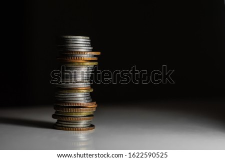 Coins stack on dark background, finance concept.