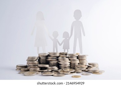 Coins Stack And The Paper Cut Of Family On Wood Table, Nature Background, Saving Money For Starting A Married Life, Building Or Financial Stability, Family Planning Concept.