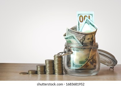 Coins Stack And US Dollar Bills In The Glass Jar. Concept Of Money Saving, Financial. Savings Money And Income Investment Ideas And Financial Management For The Future. Close Up.