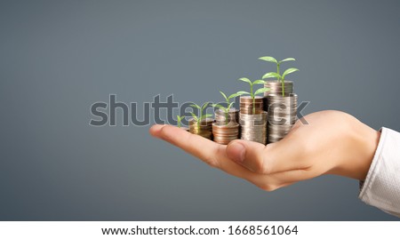 Coins stacked on each other in different positions,Man hand in business casual money