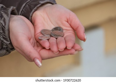 Coins In Womens Palms. Financial Hardship Concept. Background