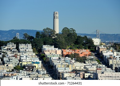 Coit Tower and the Bay Bridge as viewed from the intersection of Lombard & Hyde Street in San Francisco, California