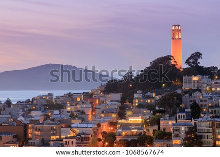Coit Tower lit orange in recognition of the San Francisco Giants. Taken from a downtown building rooftop. San Francisco, California, USA.