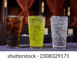 Coke or Pepsi soft drinks dark brown, lime green, clear bubbly soda beverages stage background