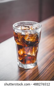 Coke Splashing From Glass On Wood Table Good Photo