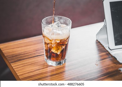 Coke Splashing From Glass On Wood Table Good Photo