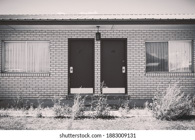 Cokeville, Wyoming - August 6, 2020: Old Abandoned Seedy Motel, With Overgrown Weeds In The Parking Lot