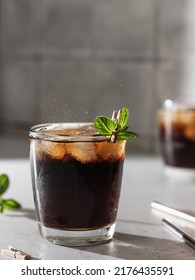 Cola Or Cuba Libre Cocktail In Glass With Ice Cubes And Mint And Metal Straws. Soft Drink Close Up. Vertical Orientation