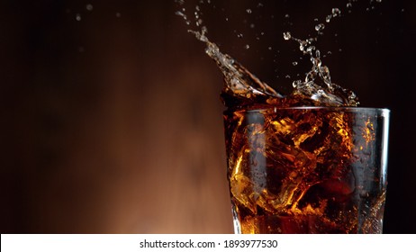 Cola drink splashing out of glass, studio shot, free space for text - Shutterstock ID 1893977530