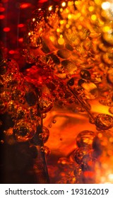 Cola in glass with ice and a bubbles of gas. Macro photo.