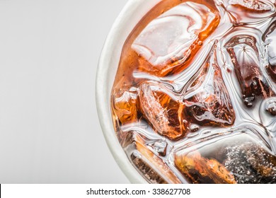 Cola In Glass With Ice On White Background, Close Up, Top View