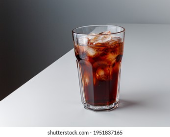Cola with Ice Cubes. Glass of cola. Copy Space. Pour soft drink in glass with ice splash on dark background. glass of cola with ice isolated. Soft drink glass with ice splash on cool smoke background.