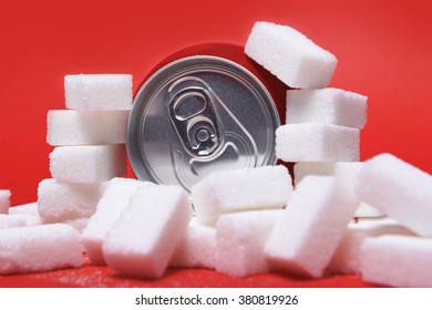 Cola Refreshing Drink Can And Lot Of White Sugar Cubes Representing The Big Amount Of Calories Content In The Soda In Unhealthy Nutrition Concept Isolated On Red Background