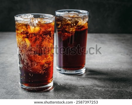 Cola soft drink with ice cubes, soda fizzy drink in Cold two glass on gray background