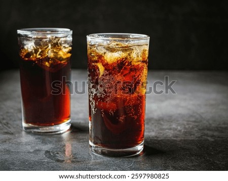 Cola soft drink with ice cubes, soda fizzy drink in Cold two glass on gray background