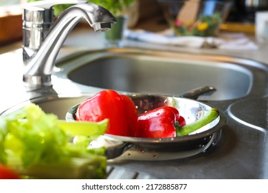 Colander With Fresh Bell Peppers In Kitchen Sink