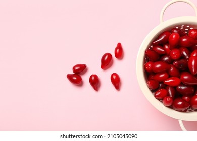 Colander With Fresh Dogwood Berries On Color Background