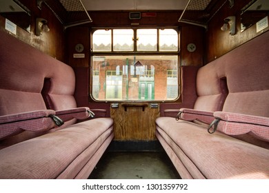Colchester / Great Britain - May 12, 2013: Interior shot of vintage railway carriage showing seating and window.  Old station building can be seen through window.
