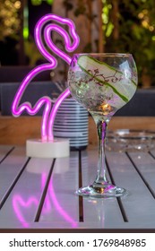 Cold Alcohol Cocktail With Cucumber In A Wine Glass On Neon Light Background. Summer Party Background.