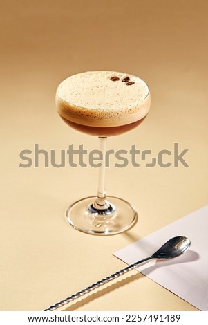 Cold alcoholic or non-alcoholic cocktail with coffee and lush foam. Hard light, deep shadow.