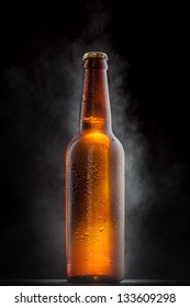Cold beer bottle with drops, frost and vapour on black