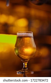 A Cold Beer On A Bar Counter With Unfocused Golden Background