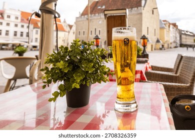 Cold beer on a checkered table at an outdoor café in the Old Town square, Tallin, Estonia.