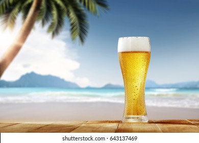 Cold beer on desk and background of summer beach with palm 
