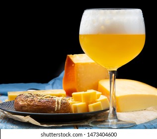 Cold Belgian Beer In Glass Served In Cafe With Variety Of Hard Cheeses, Tasty European Food Close Up