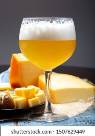 Cold Belgian Beer In Glass Served In Cafe With Variety Of Hard Cheeses, Tasty European Food Close Up