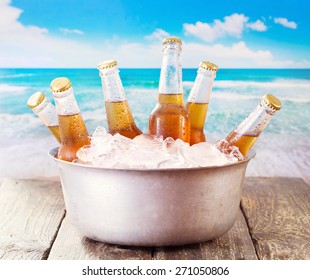 Cold Bottles Of Beer In Bucket With Ice Over Sea 