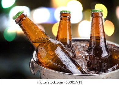 cold bottles of beer in bucket with ice in a restaurant setting - Powered by Shutterstock