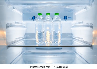 Cold bottles of clean drinking water in a white refrigerator - Shutterstock ID 2176186373