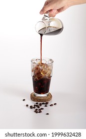 Cold Brew Coffee With Fresh Milk Pouring On. Tasty Iced Latte Cafe With Coffee Bean On Table Isolated On White Background