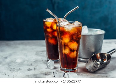 Cold brew coffee in a two glass with metal straw on a dark background.Iced coffee with ice cube.