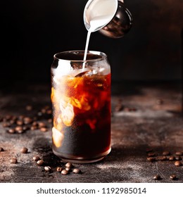 Cold Brew Iced Coffee In A Glass With Milk Or Creamer Pouring Over