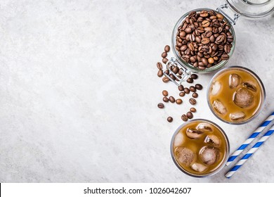 Cold brewed iced coffee in glass and coffee beans in glass jar on white background. Top view, copy space. - Shutterstock ID 1026042607