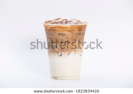 cold brewed iced latte coffee, showing separate in a layer the bottom as milk top by coffee shot in a plastic glass 16oz. isolated white background