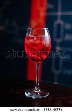 Cold cocktail with cherries in a wine glass.