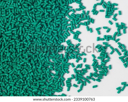 Cold cut type turquoise masterbatch granules on a white background, this material is used as a product colorant in the plastics industry