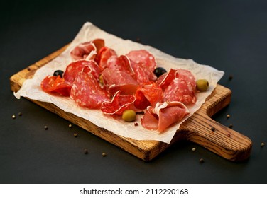 Cold Cuts - Jamon, Ham, Salami On A Wooden Board On A Black Background